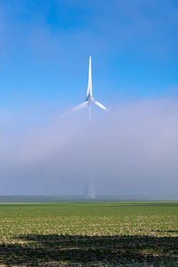 Windmill on field against sky