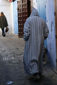 Rear view of people walking on street, morocco chefchaouen 