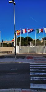 View of flag on street against blue sky