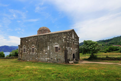 Abandoned building on field against sky