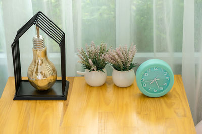 Flower vase on table by window at home