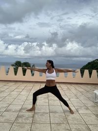 Full length of woman standing on floor against sky