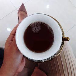 High angle view of hand holding coffee cup