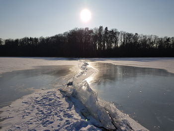 Scenic view of frozen lake against sky during winter