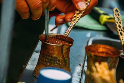 Cropped hands preparing drink