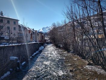Road amidst buildings against sky during winter