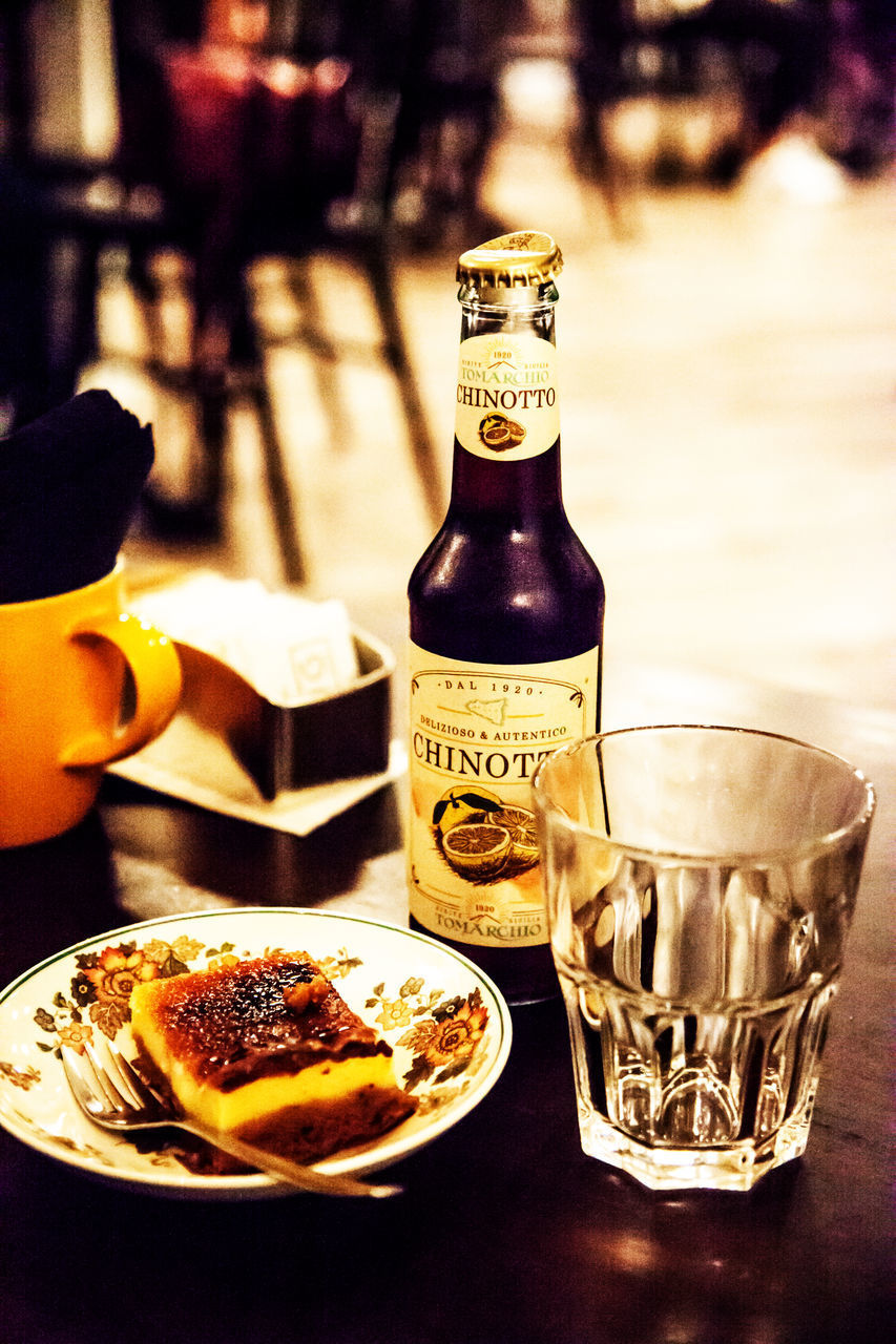 CLOSE-UP OF BEER BOTTLES ON TABLE