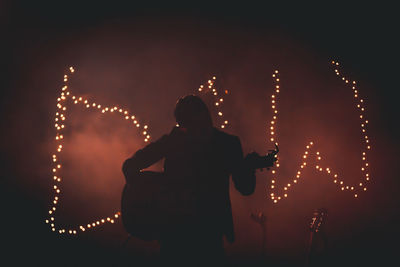 Rear view of silhouette woman at night