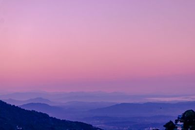 Scenic view of silhouette mountains against romantic sky at sunset