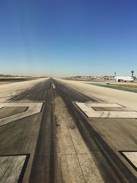 View of airport runway against clear blue sky