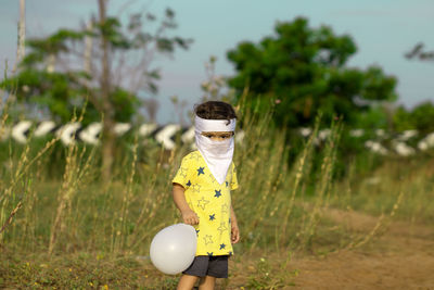 Toy standing on field by trees against sky