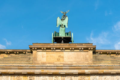 Low angle view of statue on building against sky