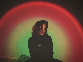 Portrait of young woman with arms raised