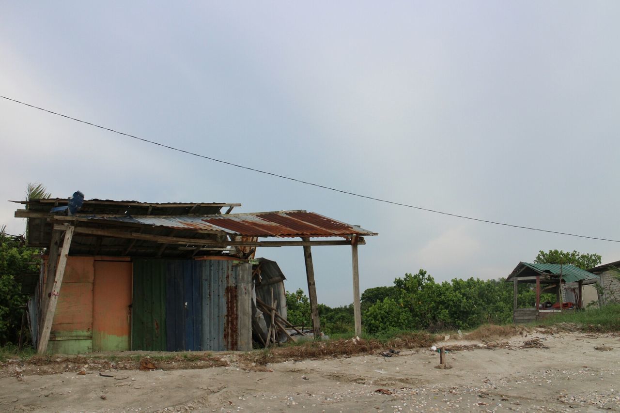 built structure, architecture, building exterior, sky, house, abandoned, low angle view, roof, damaged, day, field, old, residential structure, outdoors, rural scene, industry, copy space, hut, clear sky, no people