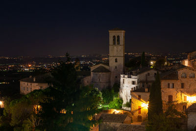 Illuminated buildings in city against sky at night