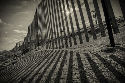 Low angle view of wooden fence on beach