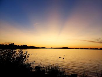 Scenic view of lake against sky during sunset