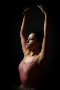Beautiful young woman over black background