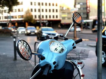 Close-up of motor scooter on road