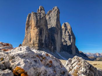 Low angle view of rock formations against clear blue sky