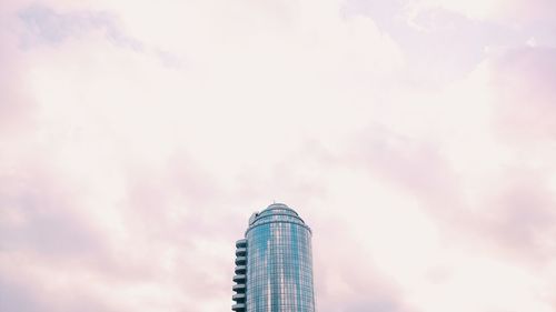 Low angle view of modern building against cloudy sky