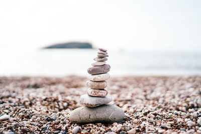 Close-up of pebbles on beach against clear sky