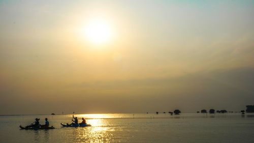 Silhouette boats in sea against sky during sunset