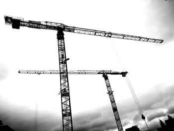 Low angle view of cranes against sky