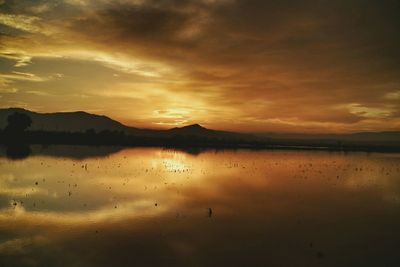 Scenic view of lake against sky during sunset