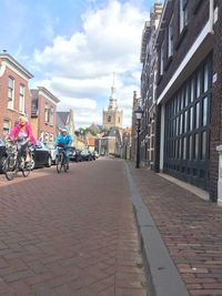 View of city street against cloudy sky