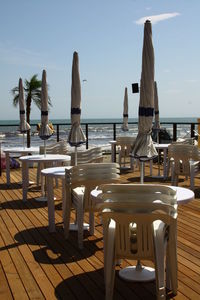 Empty chairs and tables at seaside