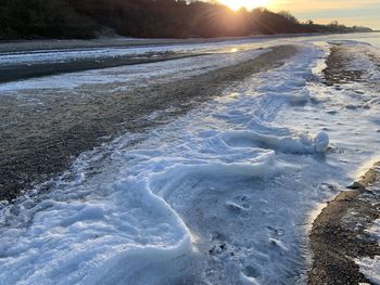 Scenic view of frozen sea during sunset