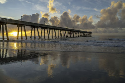 Pier over sea against sky during sunset