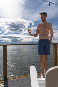 Shirtless man at seaside