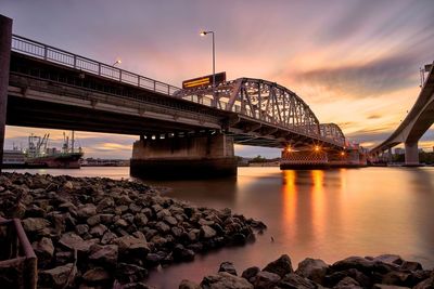 Bridge over river against cloudy sky