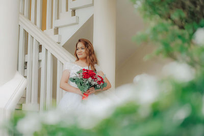 Woman sitting on plant at home