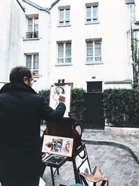 Man photographing by building