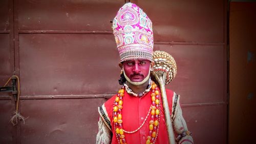 Portrait of mature man standing against wall