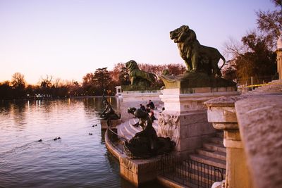 View of birds perching on statue against clear sky