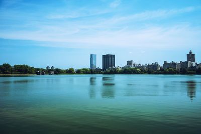 Scenic view of lake by buildings against sky