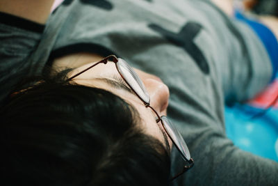 Close-up of woman wearing eyeglasses sleeping at home