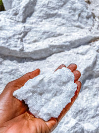 Low section of a hand holding a white quartz stone
