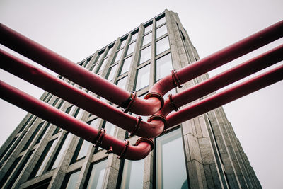 Low angle view of pipes against sky in city