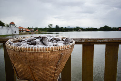 Close-up of chocolate on table by sea against sky