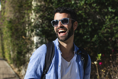 Portrait of young man wearing sunglasses standing outdoors