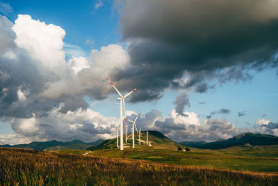 Windmill on field against sky