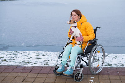 Side view of woman riding bicycle on snow