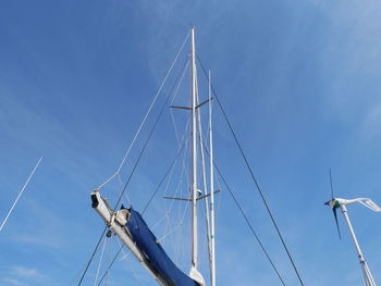 Low angle view of wind turbine against blue sky