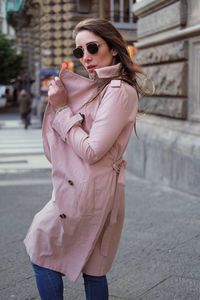 Woman holding umbrella standing on street