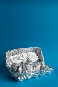 Close-up of ice crystals on rock against blue background